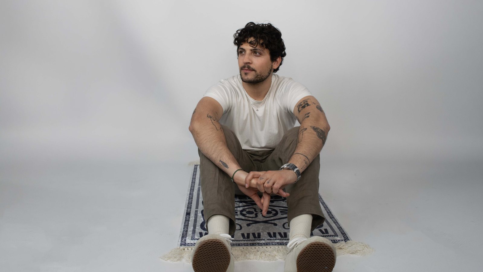 Sitting on the Ganchos rug in the studio