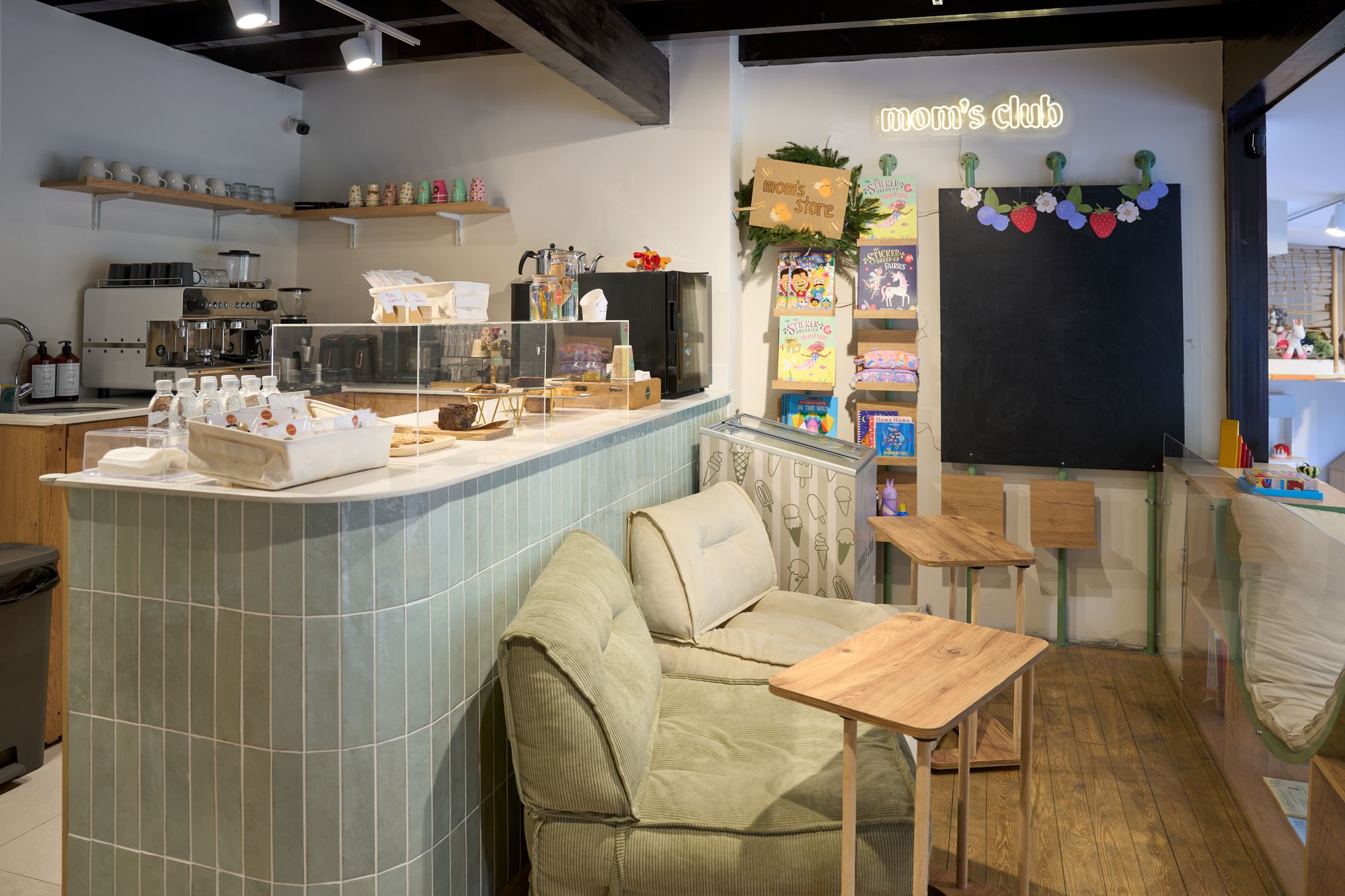 Mom's Club — café counter with neon sign and pastry display