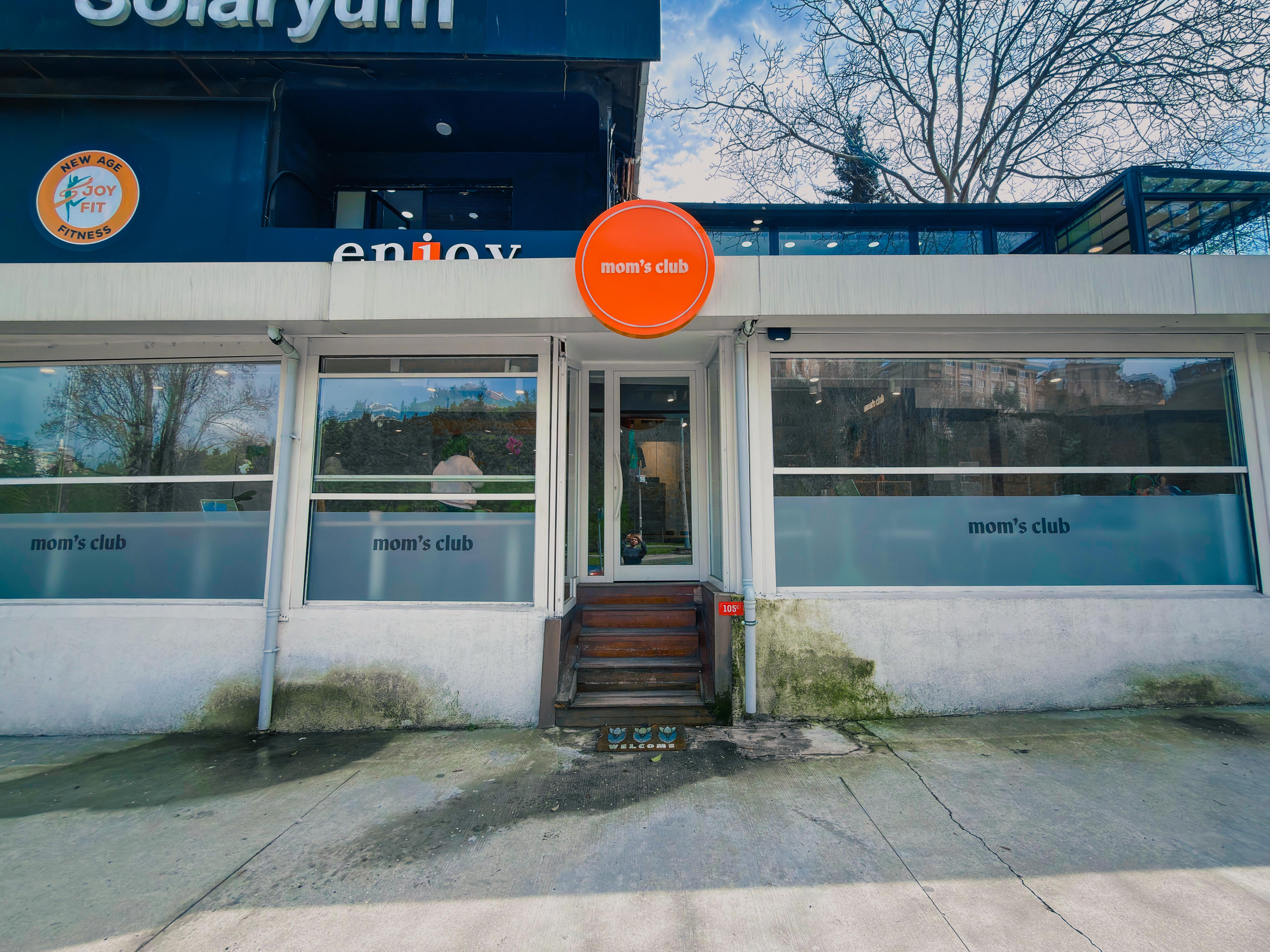 Mom's Club — exterior storefront with orange circle sign