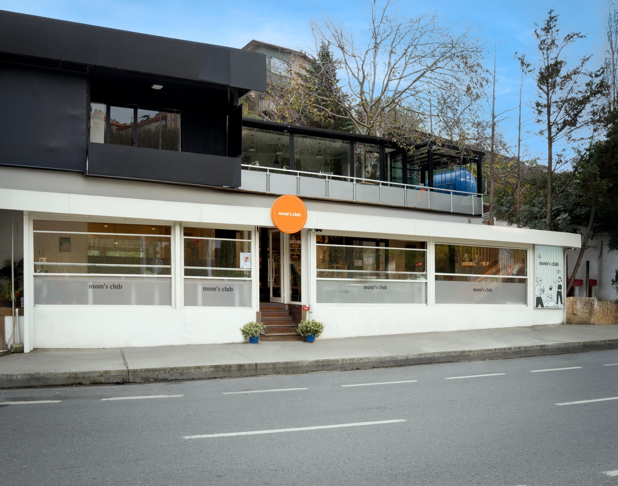 Mom's Club — exterior storefront with orange circle sign
